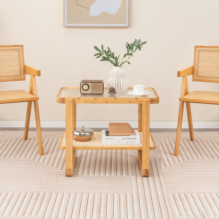 Bamboo side table with glass top and rattan shelf, perfect for living room or bedroom use, featuring a modern design.