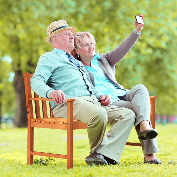 Two people enjoying a selfie on a 2-seat patio wood bench made of premium eucalyptus, perfect for outdoor relaxation.