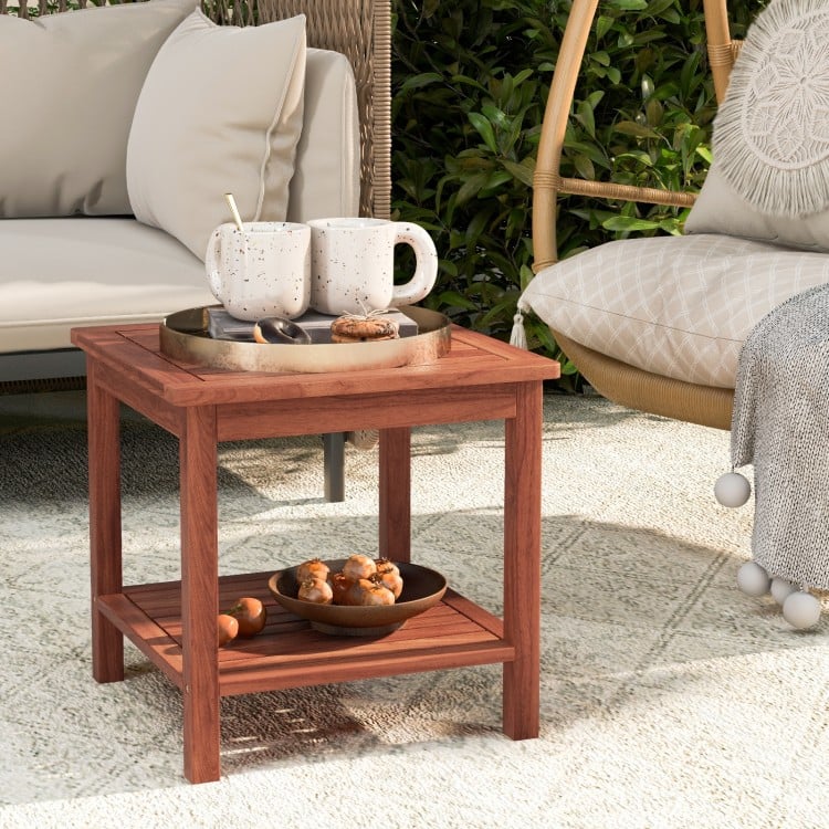 Double-tier acacia wood patio side table with slatted tabletop, perfect for drinks and snacks by the poolside.