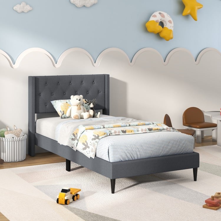Twin size upholstered platform bed in gray with button tufted wingback headboard, ideal for bedroom or guest room.
