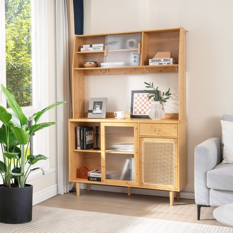 Natural bamboo kitchen cabinet with rattan door and sliding glass, showcasing a wide countertop for kitchen equipment.