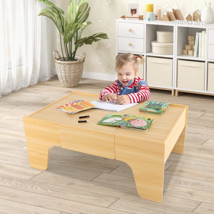 Child playing at a wooden train set table, featuring a reversible tabletop and spacious drawer for accessories.