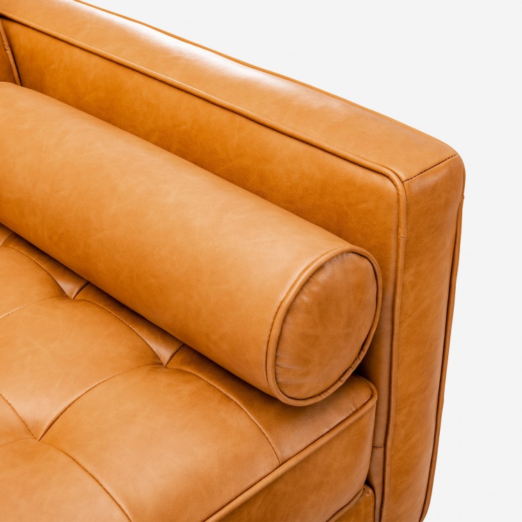 Close-up of the brown air leather backrest of a 3-seat L-shaped sectional sofa with bolster pillow for living room.