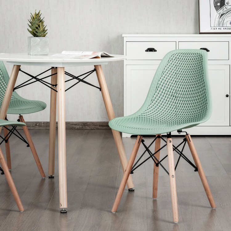 Green plastic hollow chair with wood legs, featuring ergonomic design and breathable mesh for dining room use.