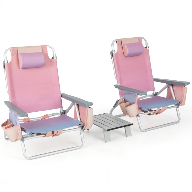 Two pink outdoor folding reclining chairs with a side table, featuring adjustable positions and cup holders for.