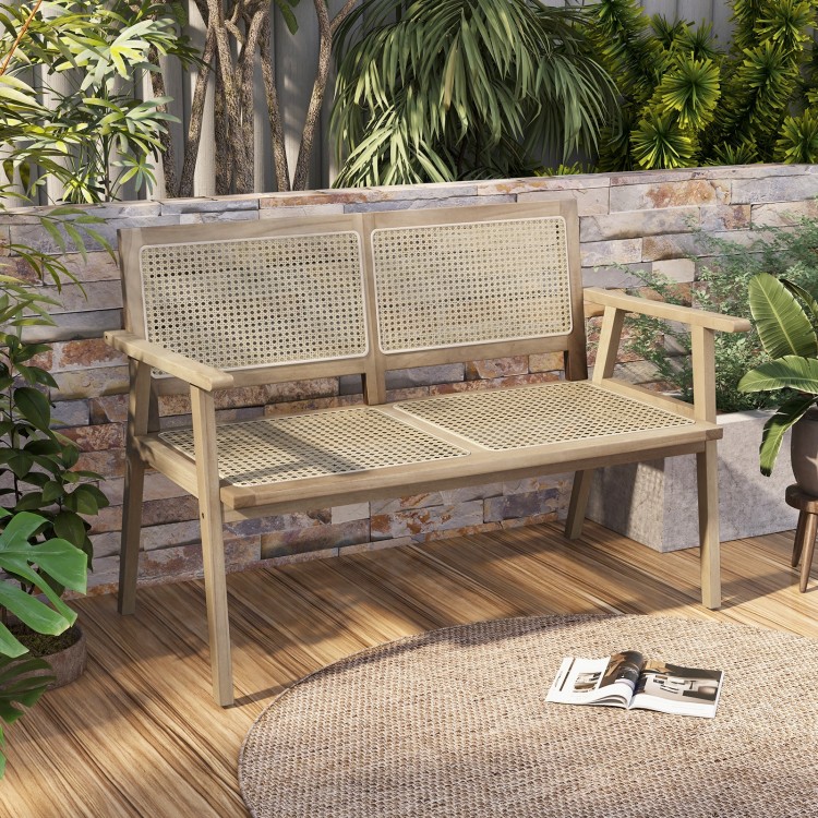 Teak wood garden bench with natural rattan backrest, designed for two, ideal for patio or garden relaxation.