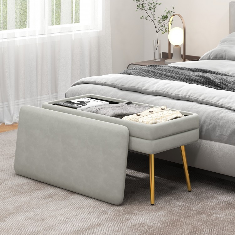 Velvet upholstered storage bench in grey with removable top, featuring gold legs, ideal for bedroom or living room use.
