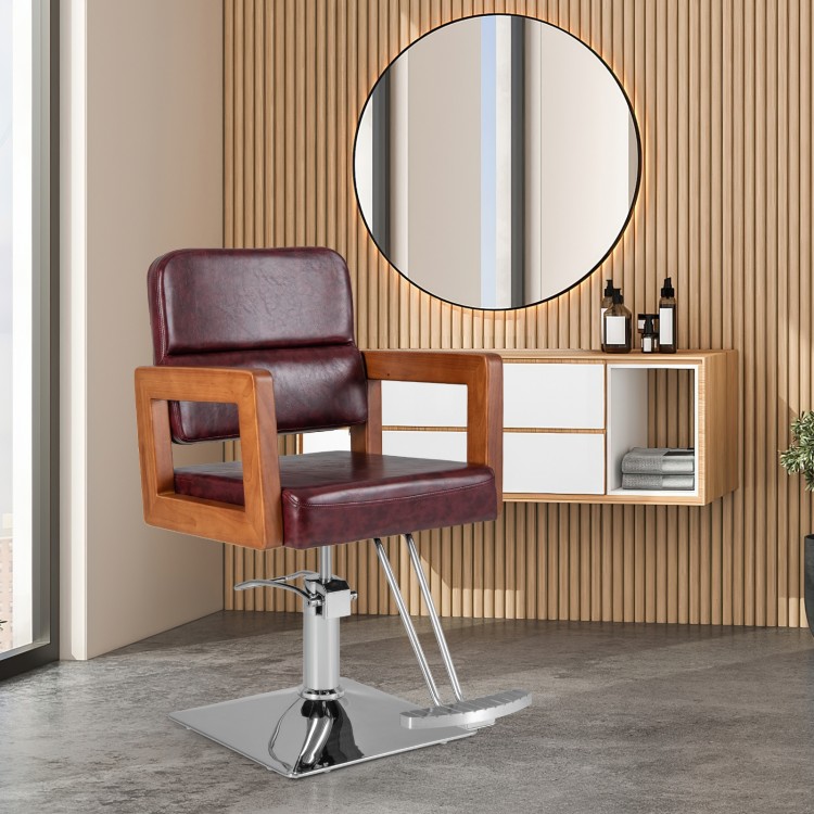 Hydraulic barber chair with red PVC leather, wooden armrests, and 360-degree swivel for hairstylist convenience.