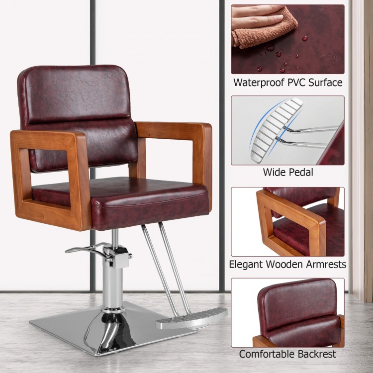 Hydraulic barber chair with red PVC surface, wooden armrests, and adjustable height for hairstylists.