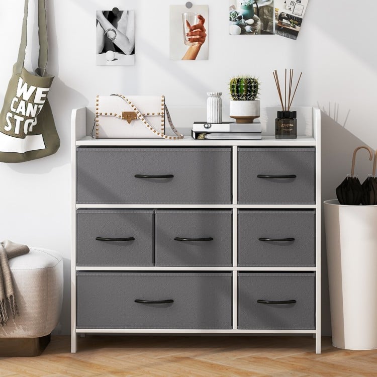 Close-up view of gray fabric drawer with metal handle, part of a white fabric dresser for organized bedroom storage.