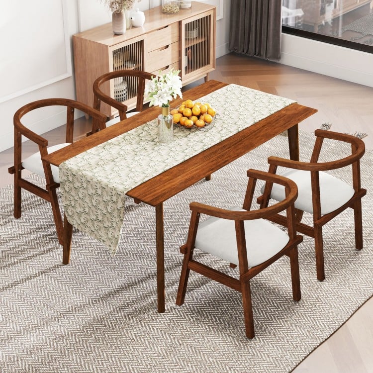 Walnut dining room table with decorative runner and four solid rubber wood chairs featuring wrap-around armrests.