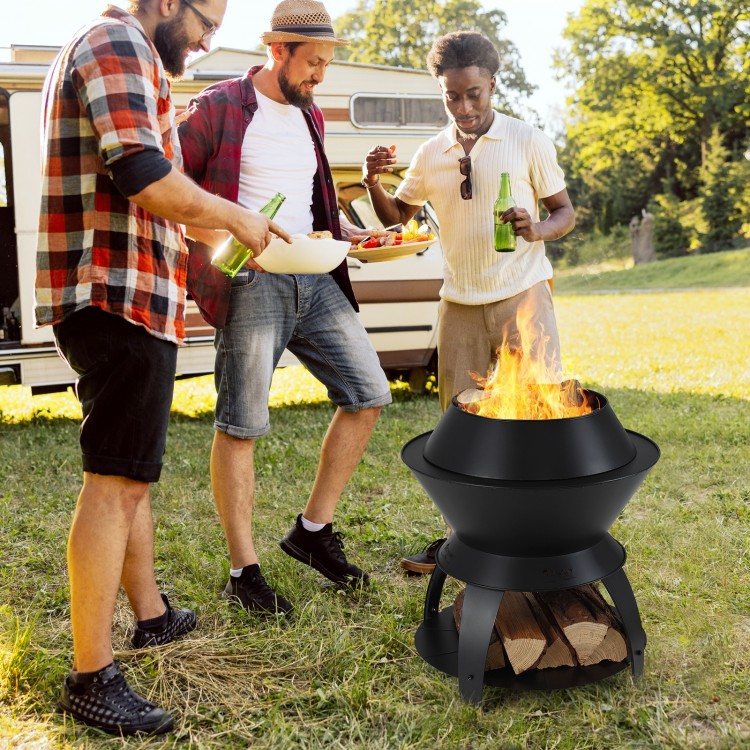 20-inch black patio fire pit with pot holder, surrounded by friends enjoying a cookout in a grassy outdoor setting.
