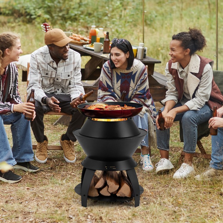 20-inch black patio fire pit with pot holder, surrounded by friends enjoying a campfire and outdoor cooking.