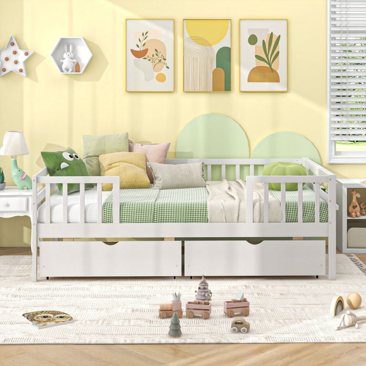 Twin daybed with fence and two drawers in white, designed for kids' safety and modern style in a playful room setting.