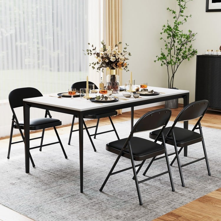 Black folding chairs with metal frame and PVC leather, set at a dining table for indoor or outdoor use.