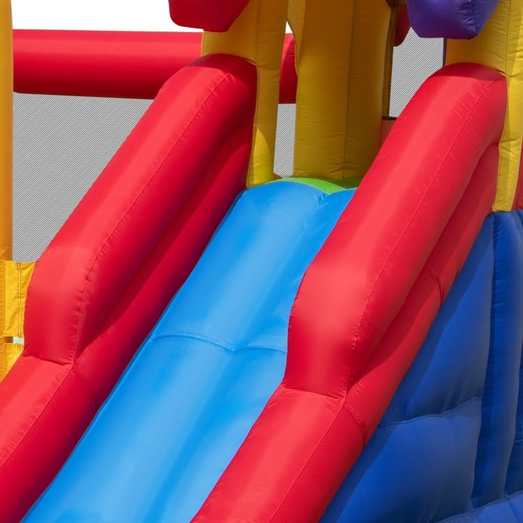 Bright red and blue inflatable bounce castle featuring double slides, ideal for outdoor fun and playtime activities.