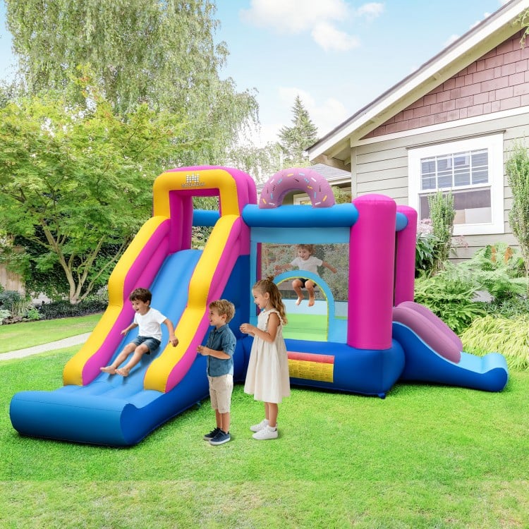Inflatable bounce house with slides and basketball hoop, featuring a doughnut theme for outdoor fun and active play.