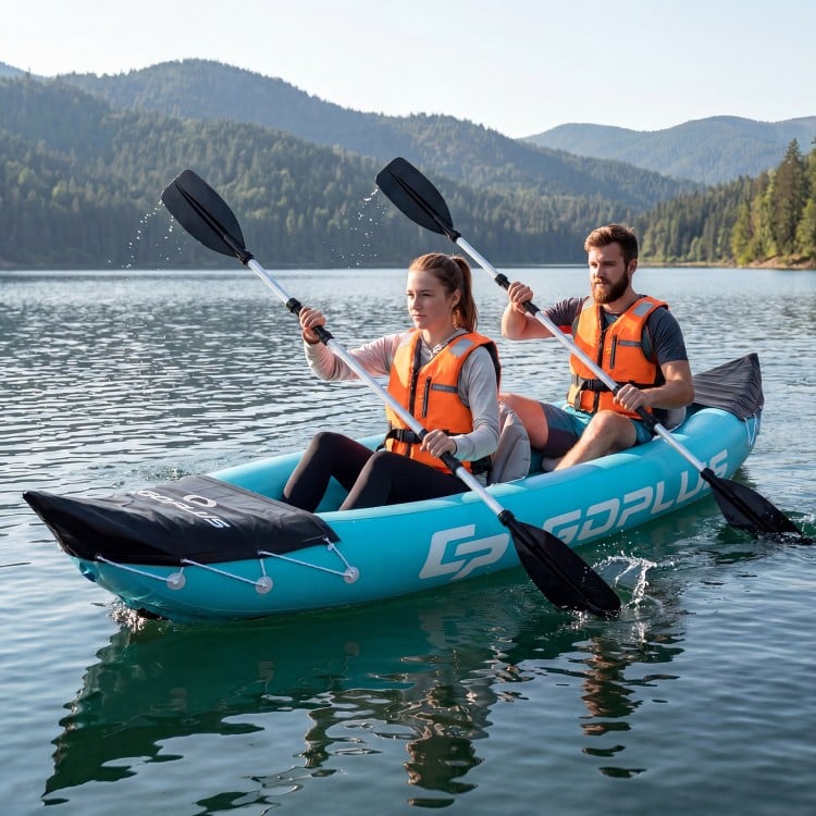Two people paddling a blue inflatable tandem kayak on a serene lake, featuring heavy-duty construction and aluminum.