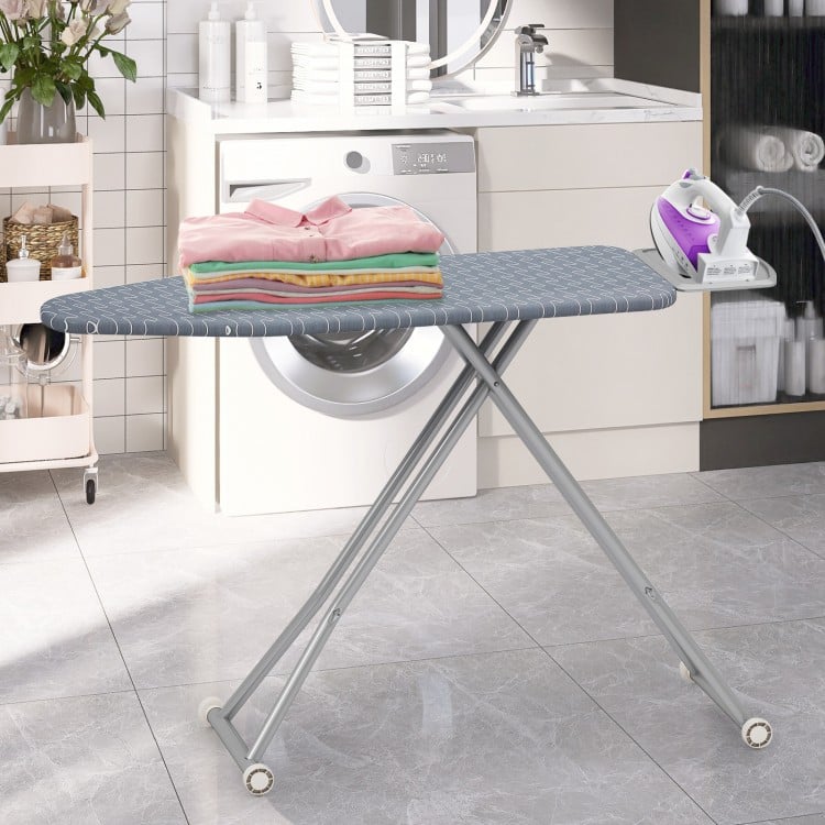 Ironing board with removable silver-gray cover, featuring an iron rest and foldable design for easy storage in laundry.