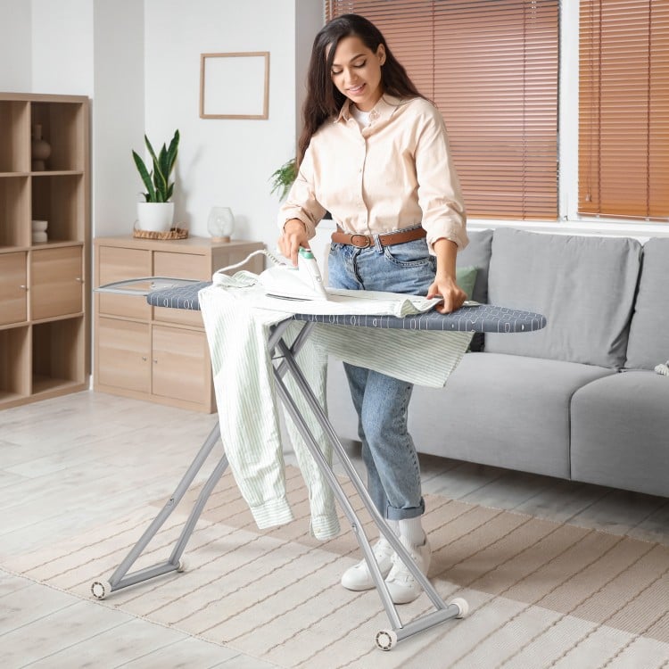 Ironing board with silver-coated cover, featuring a handy iron rest and foldable design for easy storage.