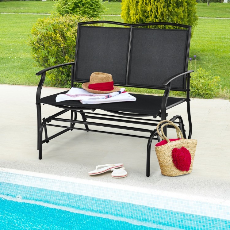 Black iron patio rocking chair for two, perfect for outdoor relaxation by the poolside with comfortable seating.