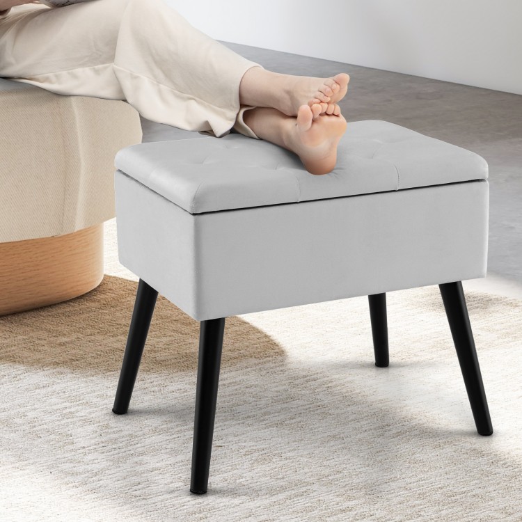 Gray velvet storage ottoman with solid wood legs, designed as a stylish footrest and spacious storage solution for any.