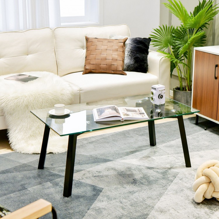 Modern tempered glass coffee table with metal frame, featuring a spacious top and sturdy legs for stylish living room.