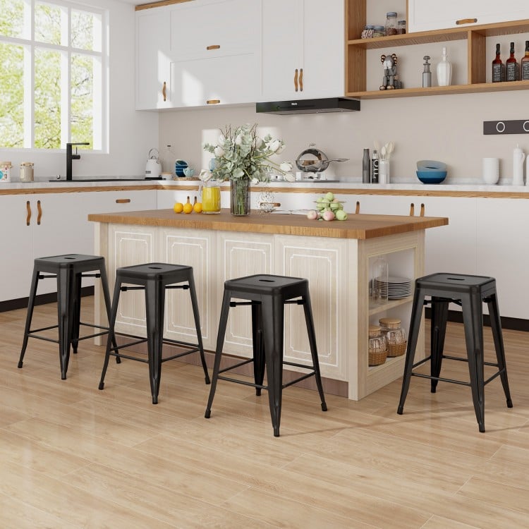 Set of 4 black Tolix style counter height barstools with stackable design, ideal for kitchen or home bar use.