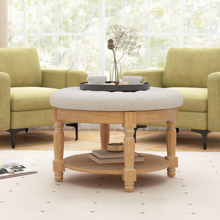 Large round beige ottoman coffee table with tufted design, flip-top storage, and rubber wood legs for living room use.