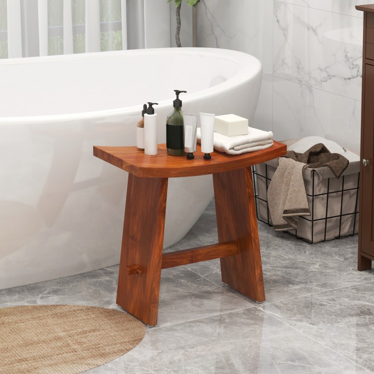 Curved teak wood shower stool with non-slip foot pads, perfect for indoor or outdoor use beside a bathtub.