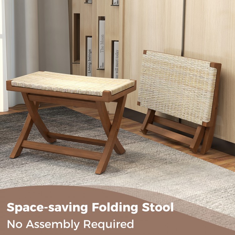 Folding natural rattan ottoman with hand-woven seat, crafted from teak wood, space-saving design for compact areas.