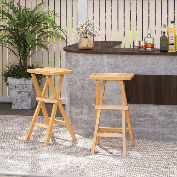 Set of 2 folding outdoor bar stools made of teak wood with ergonomic saddle seats for comfortable seating.