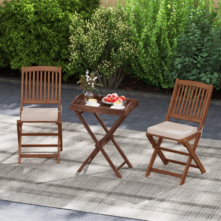 Teak wood tray table with removable top and two folding chairs, perfect for outdoor patio dining and relaxation.