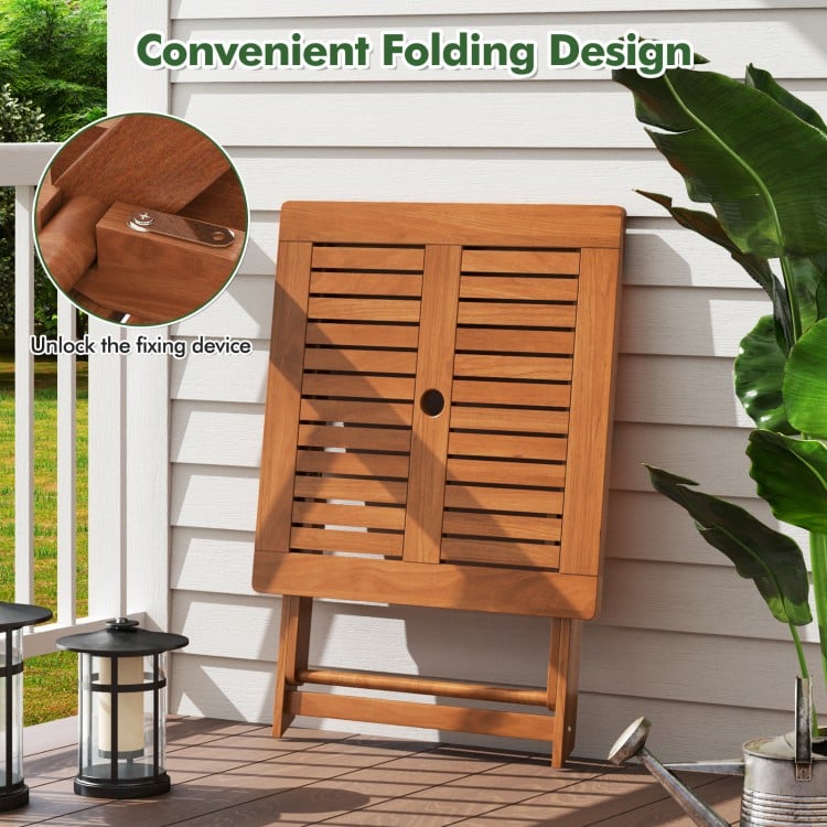 Folding patio dining table with teak finish, featuring an umbrella hole, ideal for backyard and poolside use.