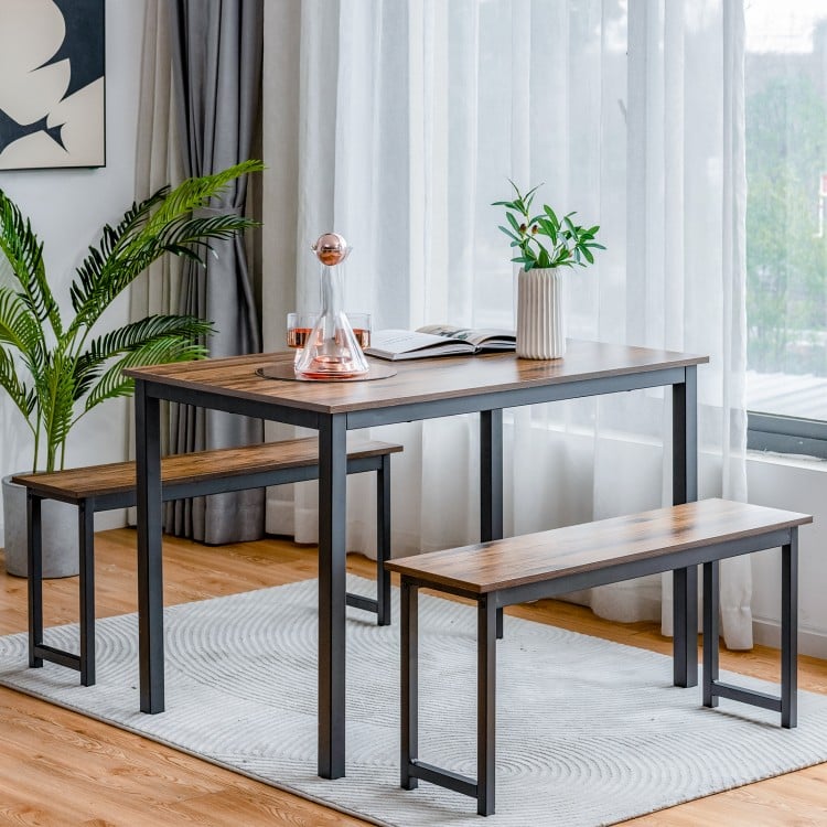 Dining table set featuring a brown tabletop and black metal frame, includes two benches, ideal for small spaces.