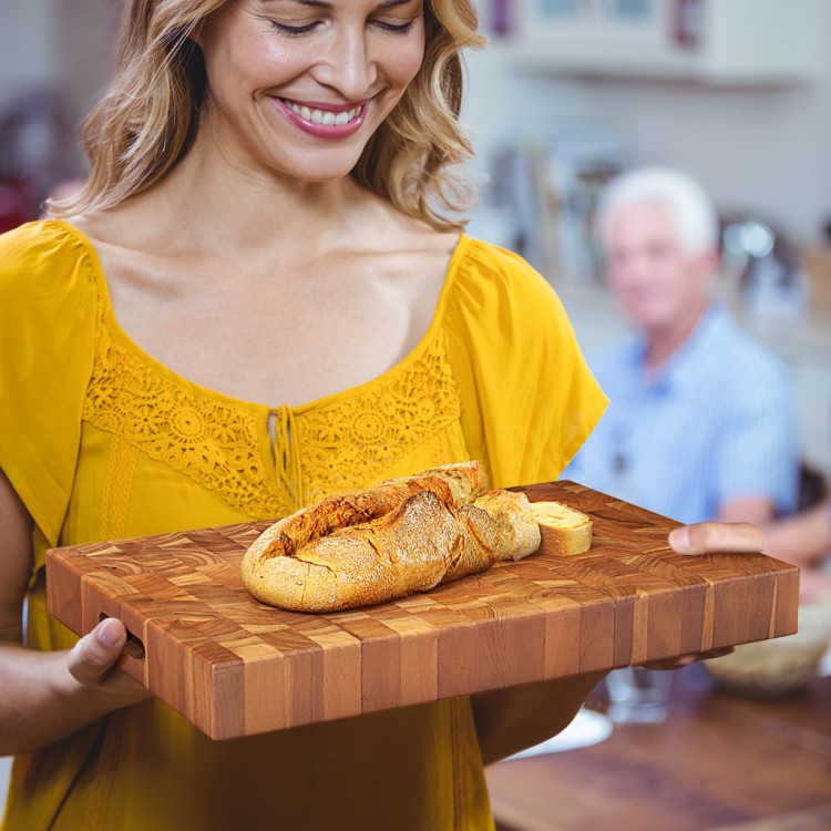 End grain cutting board made of solid teak wood, featuring hand grips, perfect for slicing and serving in the kitchen.