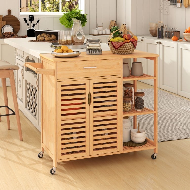 Kitchen island cart on wheels with bamboo frame, featuring storage drawer, cabinet, and shelves for versatile kitchen.