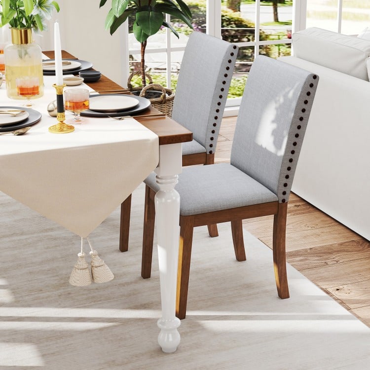Set of 2 upholstered dining chairs with padded seat and walnut frame, featuring decorative nailhead trim for elegance.