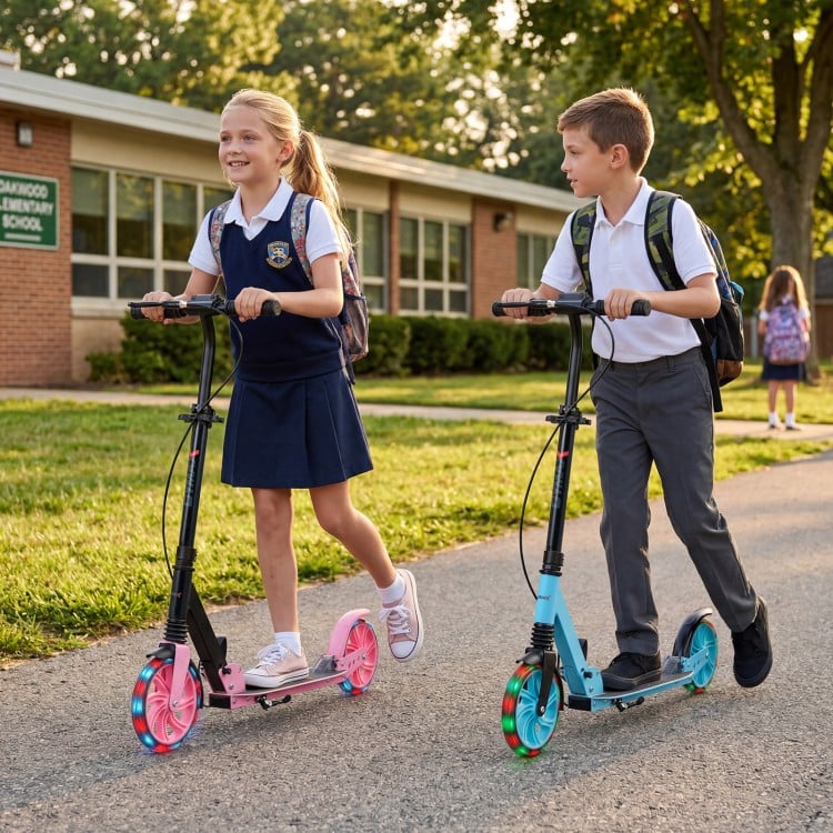 Kids riding the blue foldable kick scooter with large light-up wheels, perfect for ages 8 and up, on a school path.