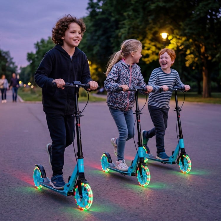 Three kids riding blue foldable kick scooters with large light-up wheels in a park during twilight.