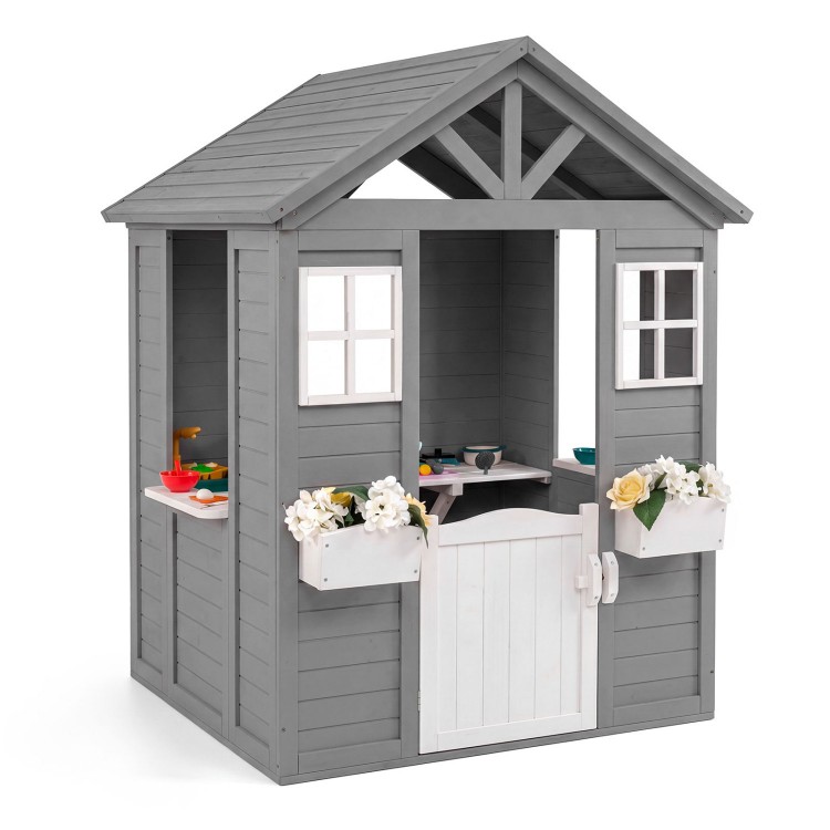 Gray wooden kids outdoor playhouse with sink, half door, and flower boxes for imaginative play in the backyard.