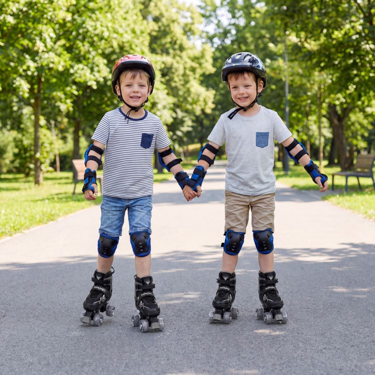 Two children holding hands while roller skating in a park, wearing adjustable black roller skates with light-up wheels.