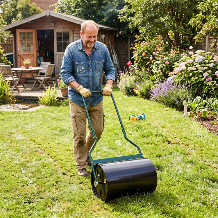 Lawn roller with U-shape handle, 12-gallon water/sand filled, used for leveling grass in a garden setting.