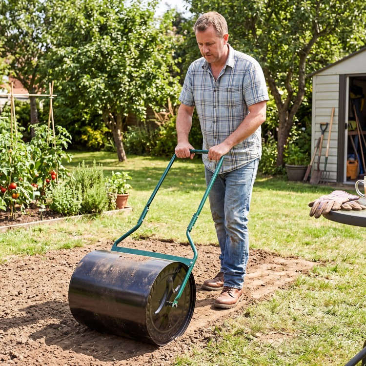 Lawn roller filled with water or sand, 12-gallon capacity, used for leveling garden soil in a backyard setting.