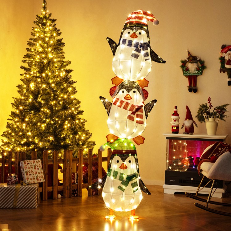 Lighted penguins decoration with warm white lights, featuring festive hats and scarves, perfect for Christmas displays.