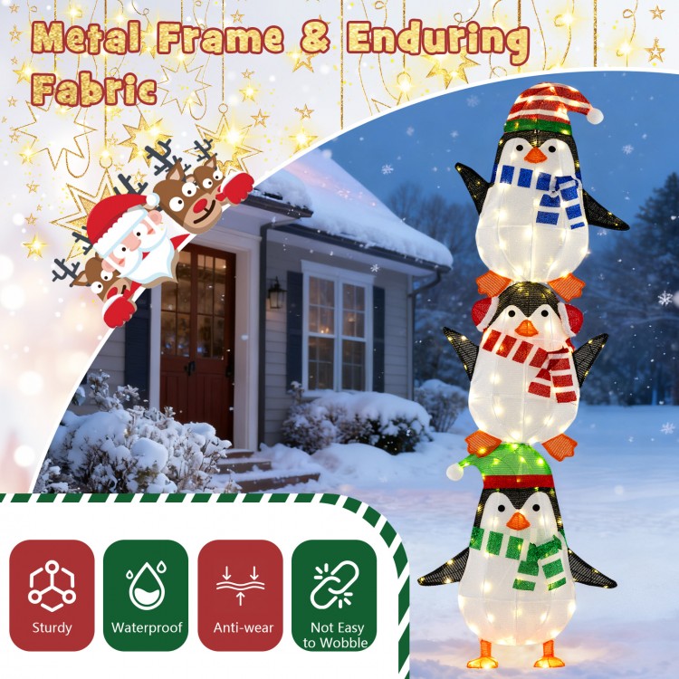 Lighted penguin decoration with warm white lights, featuring hats and scarves, ideal for festive outdoor displays.