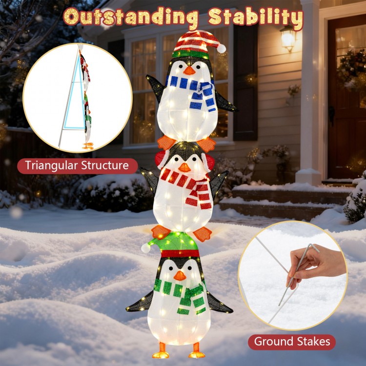 Lighted penguins decoration with warm white lights, featuring hats and scarves, ideal for festive outdoor displays.