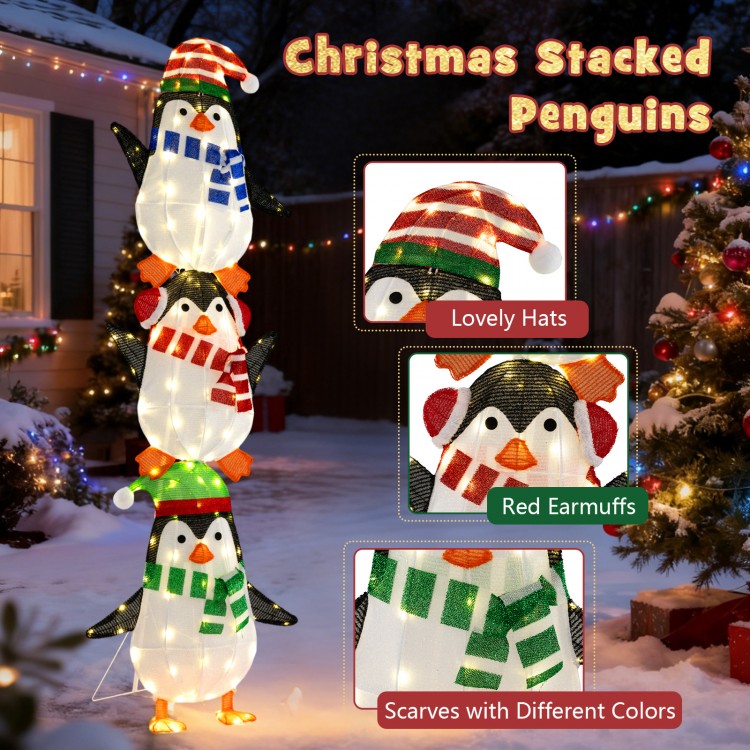 Stacked penguin decoration with warm white lights, featuring cute hats, earmuffs, and scarves for festive outdoor.