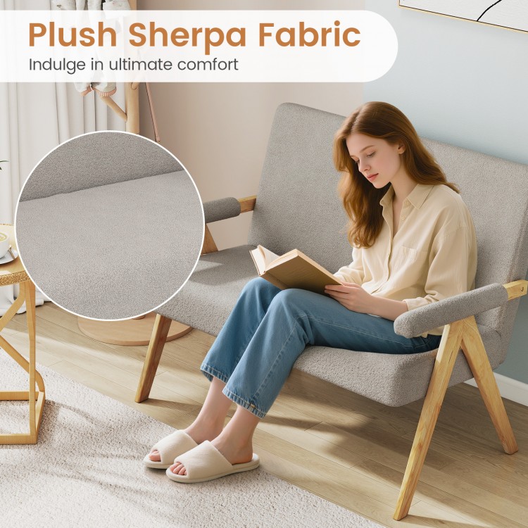 Gray loveseat sofa with plush sherpa fabric, upholstered armrests, and wooden legs, perfect for small spaces.
