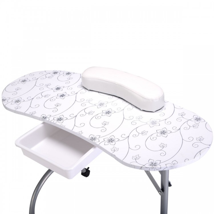 Foldable portable manicure table with floral design, white cushion, drawer, and casters for easy mobility and storage.